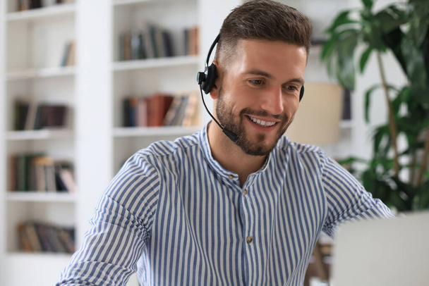 Cheerful young support phone male operator in headset, at workplace while using laptop, help service and client consulting call center concept. - Zdjęcie, obraz