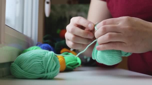 Eine Frau strickt einen Haken aus grünem Garn - Filmmaterial, Video