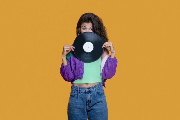 Cute dark-haired young girl holding a record - Φωτογραφία, εικόνα