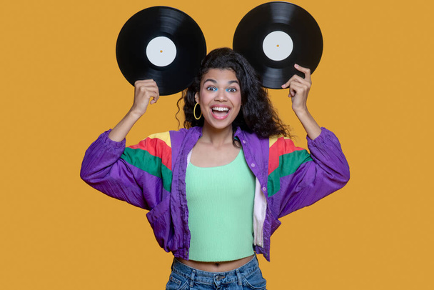 Cute dark-haired young girl holding records and having fun - Fotó, kép