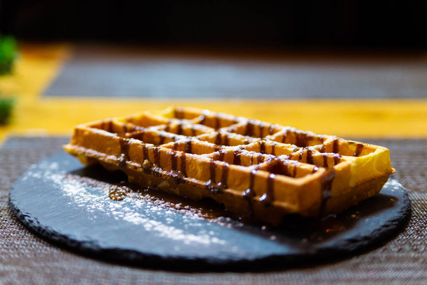 Belgische wafel met chocoladesiroop en poedersuiker. - Foto, afbeelding