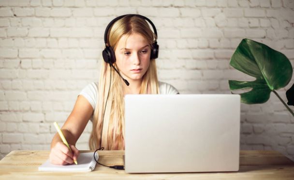 Παιδιά στο σπίτι σχολείο, έφηβος κορίτσι με ακουστικά που σπουδάζουν σε απευθείας σύνδεση στο σπίτι, e-learning έννοια - Φωτογραφία, εικόνα