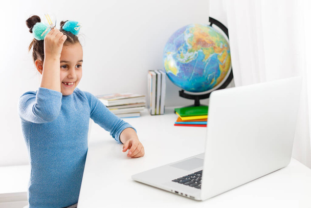 istruzione, scuola, tecnologia e concetto di internet - piccola studentessa che punta al computer portatile con lampadine a scuola - Foto, immagini