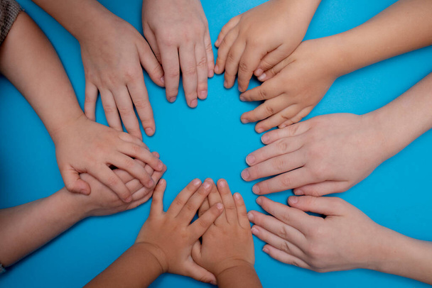 Cinco niños juntando sus manos, acostados. Familia feliz - Foto, imagen