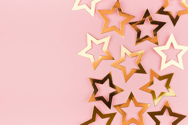 Luxury glamour gold stars on soft light pastel pink festive background, flat lay, border. - Foto, imagen