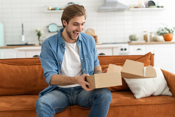 Happy man customer unpacking cardboard box receive open post mail delivery package - Φωτογραφία, εικόνα
