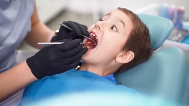 Donna medico in clinica dentale, servire paziente bambino con denti danneggiati del bambino - Filmati, video