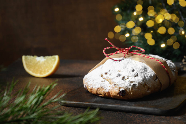 Christmas fresh stollen on brown table decorated garland. Close up. Holiday Xmas food. - Foto, Imagen
