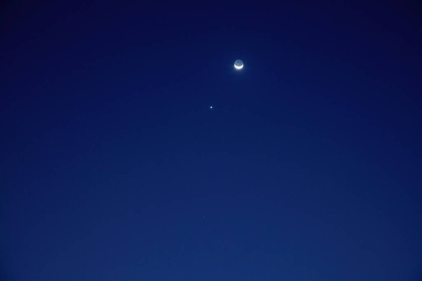 Астрономическое соединение Венеры и Луны, сфотографированное с длинным фокусным объективом. - Фото, изображение