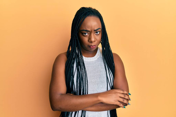 Jonge Afro-Amerikaanse vrouw draagt nonchalante kleren sceptisch en nerveus, afkeurende uitdrukking op gezicht met gekruiste armen. negatieve persoon.  - Foto, afbeelding