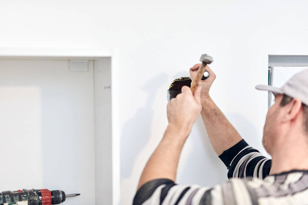 Handyman worker fixing and assembling household furniture. - Zdjęcie, obraz
