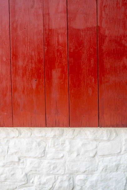 Vertical bois rouge vif et mur extérieur en pierre blanchie à la chaux gros plan. - Photo, image