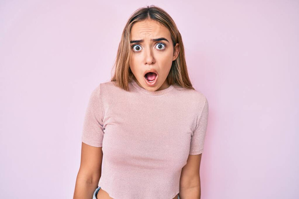 Young beautiful blonde woman wearing casual clothes scared and amazed with open mouth for surprise, disbelief face  - Photo, Image