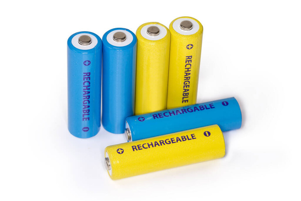 Žluté a modré dobíjecí baterie velikosti AA na bílém pozadí, detailní záběr ve výběrovém zaostření - Fotografie, Obrázek