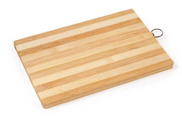 Tabla de cortar hecha de piezas pegadas de madera de bambú natural de forma rectangular sobre un fondo blanco - Foto, imagen