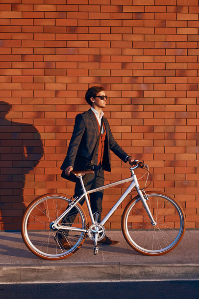 Modern businessman walking with bicycle on street - Fotoğraf, Görsel
