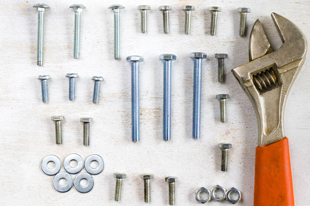 Monkey wrench and bolts on the white background, high angle view - Photo, Image