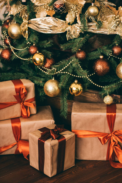 Cajas de regalo y árbol de Navidad de oro, regalos envueltos y decoración en estilo país como decoración de la casa de vacaciones - Foto, Imagen