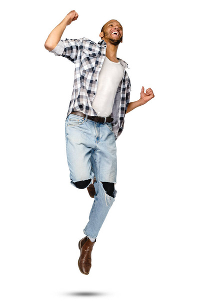 Casual african-american man jumping in studio over white background - Φωτογραφία, εικόνα