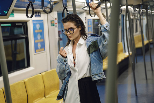 Sexy and beautiful model is posing in carriage of metro train - Foto, afbeelding