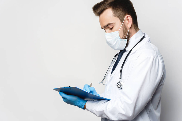 Young and confident doctor is holding the clipboard with a documents - Foto, immagini