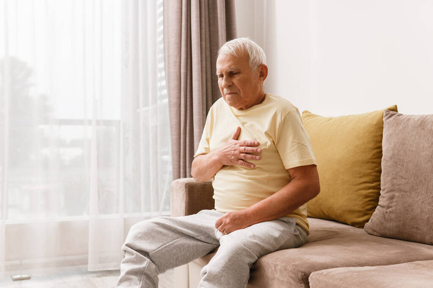 Senior man have pain in chest. Concepts of different problems like acid reflux or heart attack. - Φωτογραφία, εικόνα