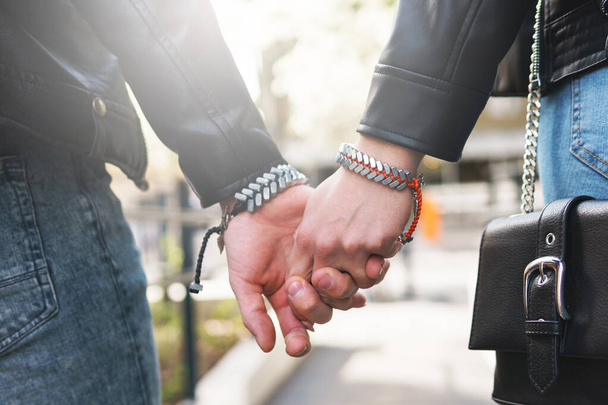 Joven pareja amorosa cogida de la mano durante una cita al aire libre - Foto, imagen