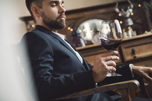 Portrait of handsome bearded man with a glass of red wine - Zdjęcie, obraz
