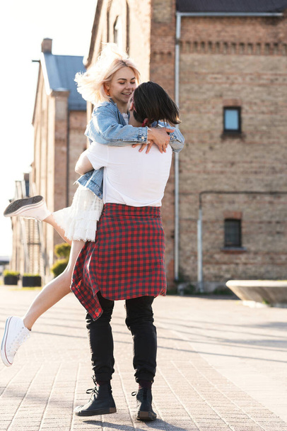 Reunion of teen couple. Stylish teenagers in embrace on a city street during their date. - Foto, Imagen