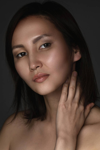 Portrait of young and beautiful asian woman on gray background - Fotó, kép
