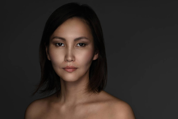 Portrait of young and beautiful asian woman on gray background - Valokuva, kuva