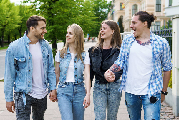 Group of best friends are having in a city park. Young people happy to see each other during a meeting. - Valokuva, kuva