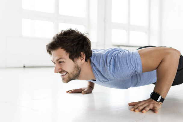 Young man doing push-ups during calisthenic workout in the gym - Fotoğraf, Görsel