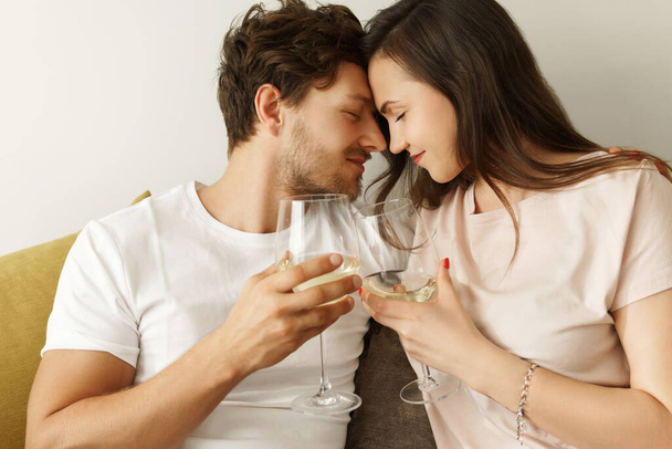 Young sensual couple drinking white wine and relaxing at home - Valokuva, kuva