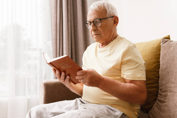 Älterer Mann liest zu Hause die Bibel - Foto, Bild