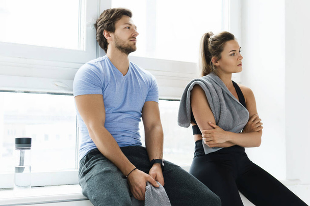 Man and woman resting after fitness workout in the gym - Photo, image