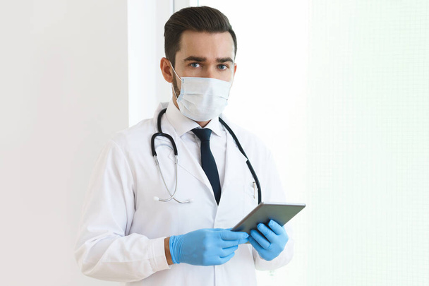 Young and confident doctor is using tablet pc for his work  - Φωτογραφία, εικόνα