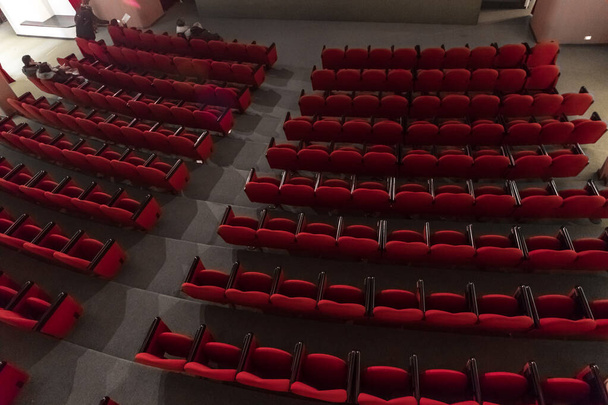 women in cinema, red chairs in rows in theatre  - Photo, Image
