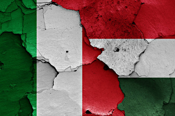 イタリアとハンガリーの旗が割れた壁に描かれています - 写真・画像