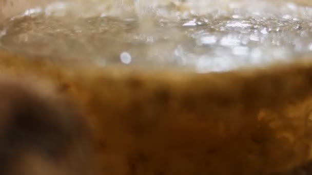 Lähikuva kaatamalla kuumaa vettä läpinäkyvä teekannu kuivattuja kehäkukka kukkia. Valmistelu infuusio kehäkukka kukkia rohdoshoitona. Terveellisen elämäntavan käsite. 4K-video - Materiaali, video
