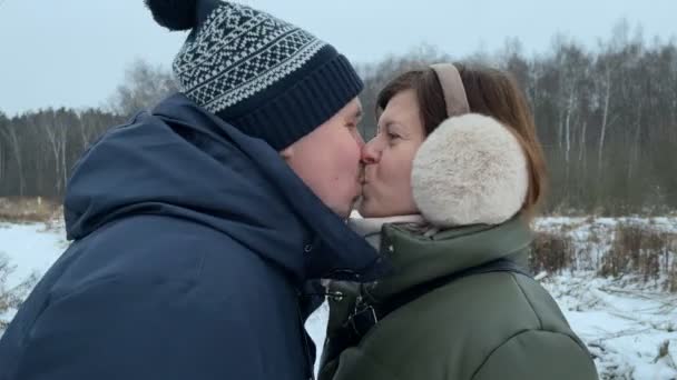 Молодая пара целуется в зимнее время на открытом воздухе. - Кадры, видео