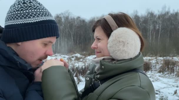 Young couple at winter time. Husband warms wife hands and kiss her. - Footage, Video