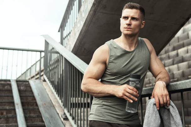 Handsome muscular man after jogging workout on a city street - Foto, Imagem