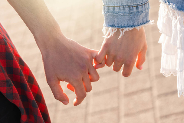 Young couple holding hands with a pinky grip - Фото, зображення