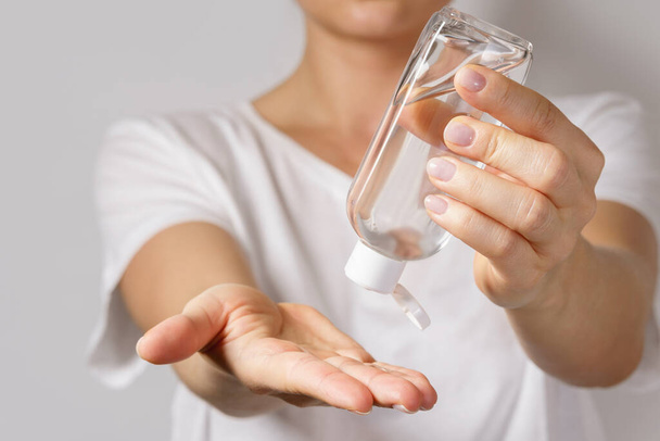 Hygiene and health concept. Woman with a small bottle of hand sanitizer - Foto, afbeelding