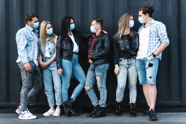 Group of friends wearing prevention masks during a meeting on a street - Foto, imagen