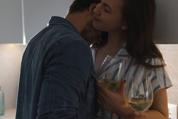 Young and sensual couple drinking wine and relaxing at home - Valokuva, kuva