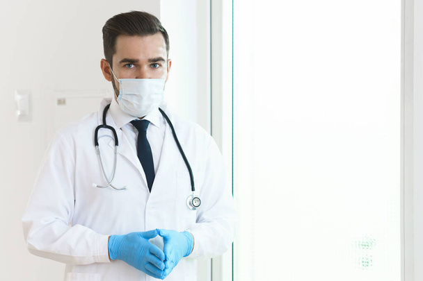 Young and confident doctor wearing prevention mask in the hospital - Photo, image
