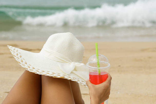 Fiatal nő egy piros frissítő ital a strandon - Fotó, kép