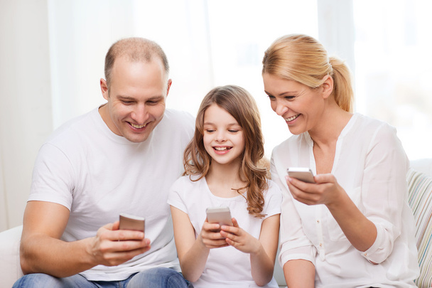 両親と自宅でスマート フォンを持つ少女 - 写真・画像
